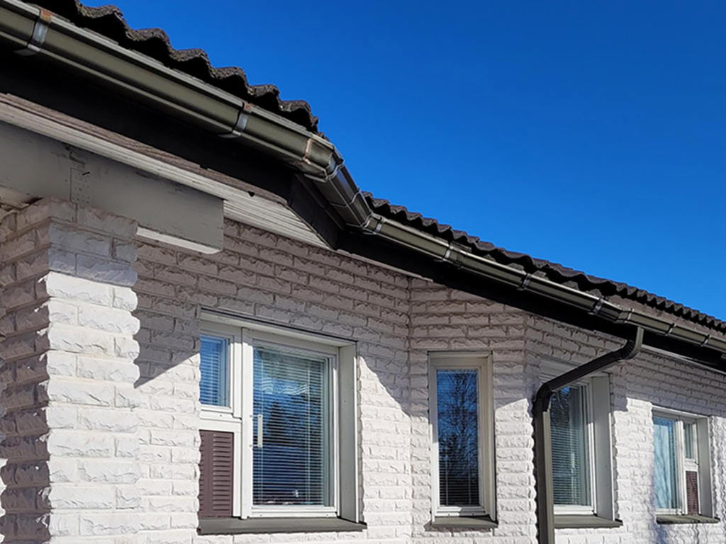 Kantikas-sadevesijarjestelma-Kouruset Musta kantikas sadevesijärjestelmä valkoisessa tiilitalossa