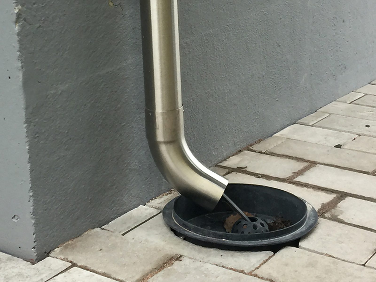 Sadevesikaivo ja RST-alastulo talon seinän vieressä