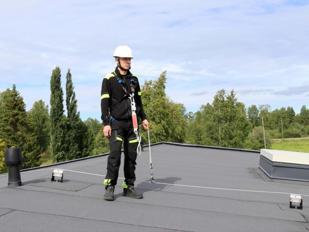 Vaijerijarjestelma-Kouruset Huoltomies katolla kiinnitettynä turvaköydellä vaijerijärjestelmään